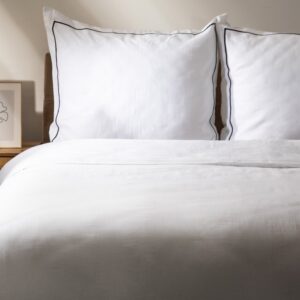 Duvet Set Esperin – Elegant white cotton satin duvet cover set featuring a minimalist design with subtle dark piped edging. Includes one large duvet cover and two matching pillowcases, each showcasing crisp tailoring and premium quality for a luxurious bedroom look. Perfect for stylish home décor, modern bedrooms, and lovers of refined minimalist bedding. Ideal for king or queen size beds, creating a fresh, inviting, and sophisticated ambience.